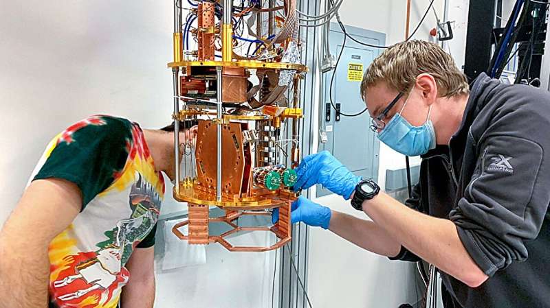 Doctoral candidates Zachary Huber, left, and Ben Keller install detector array components for the Simons Observatory in one of the dilution refrigerators in Michael Niemack’s laboratory. Credit: Michael Niemack Simons Observatory begins measurements to probe Big Bang inflation